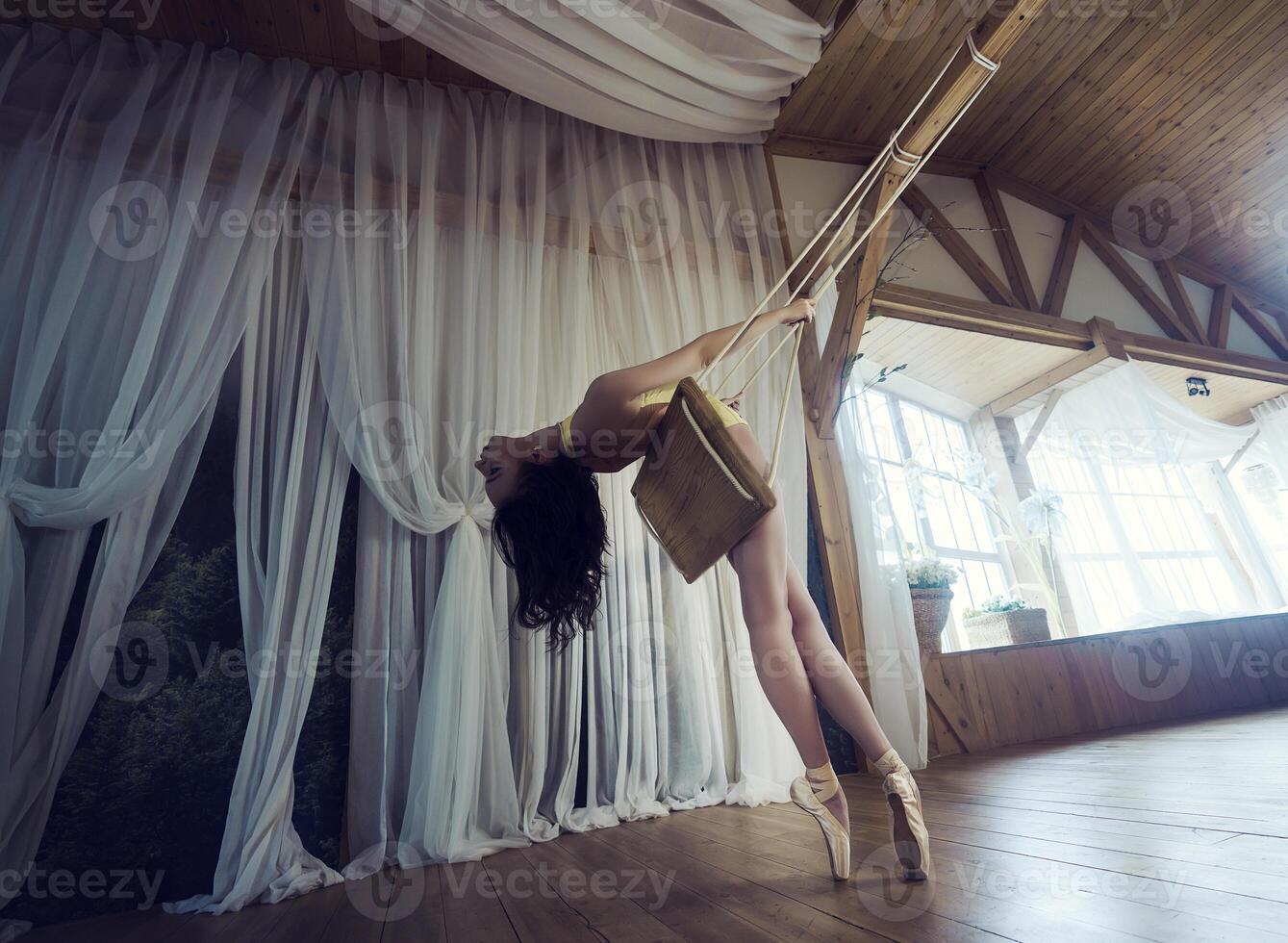 Romantic picture of a ballerina, a ballerina in pointe shoes, swinging on a swing, a ballerina in a leopard photo