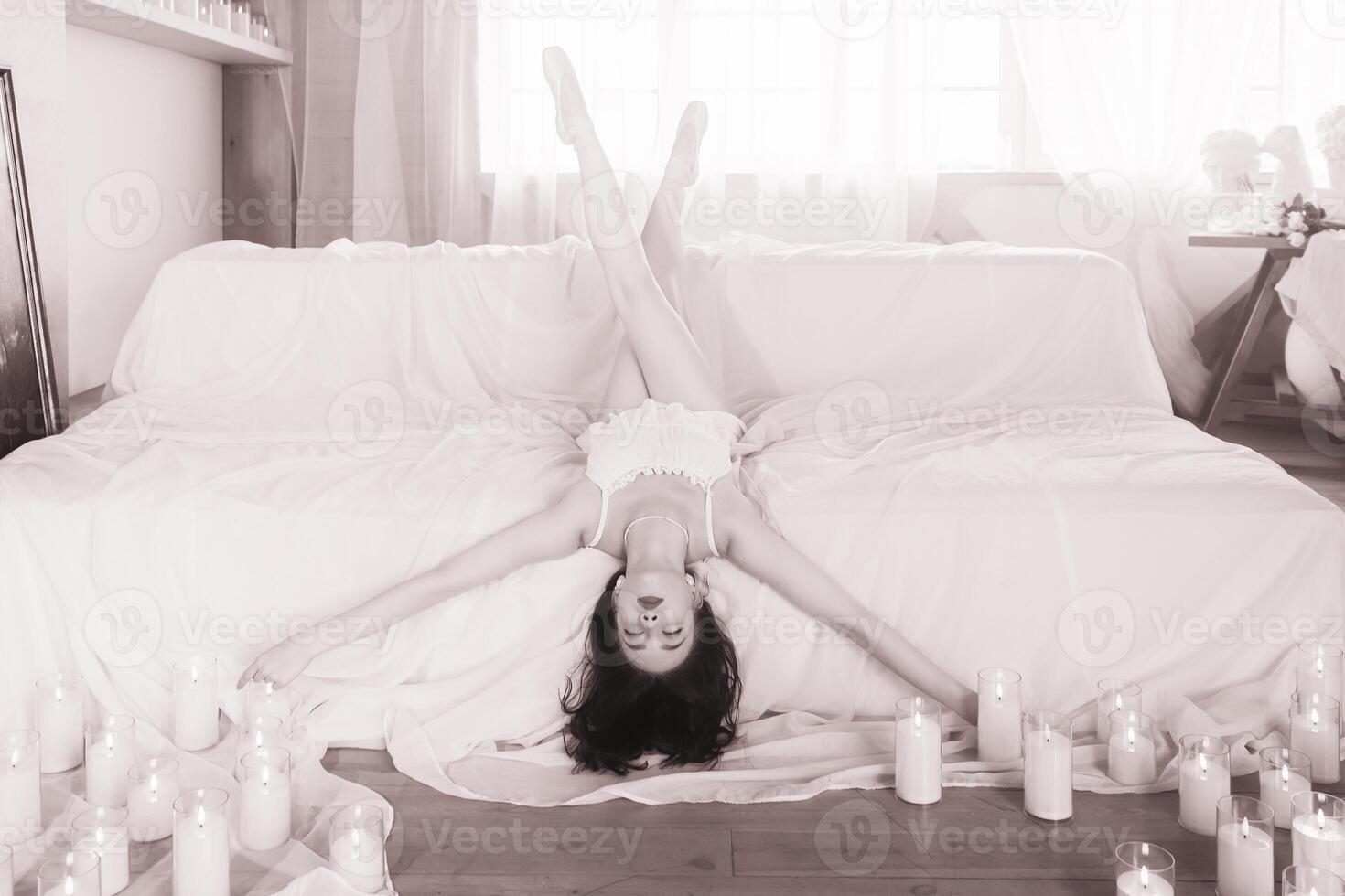Beautiful romantic ballerina, ballerina in pointe shoes and pyjamas lying on a sofa surrounded by candles, ballerina in leopard. photo
