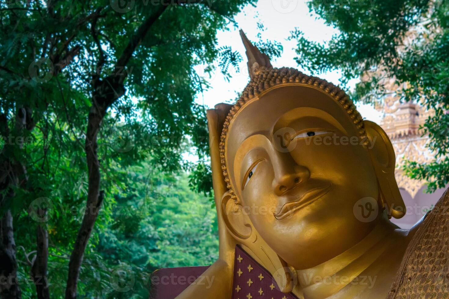 A golden buddha statue is sitting in the shade photo