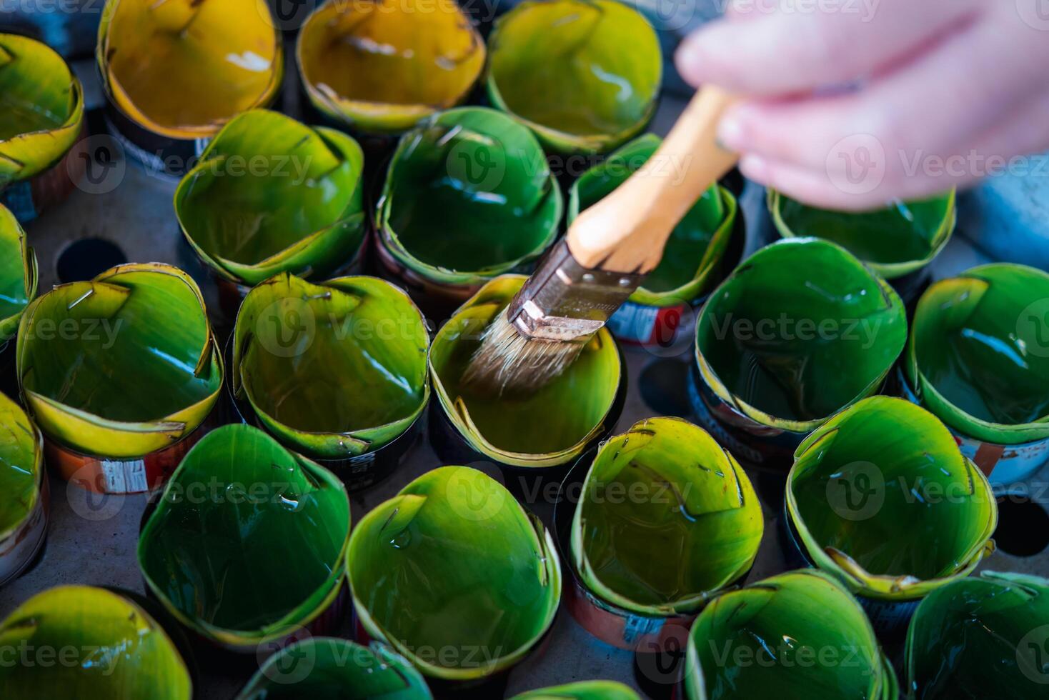 A person is painting green and yellow cups photo