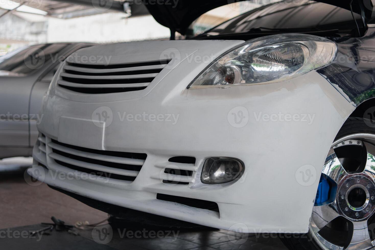 A white car is being worked on by a mechanic photo