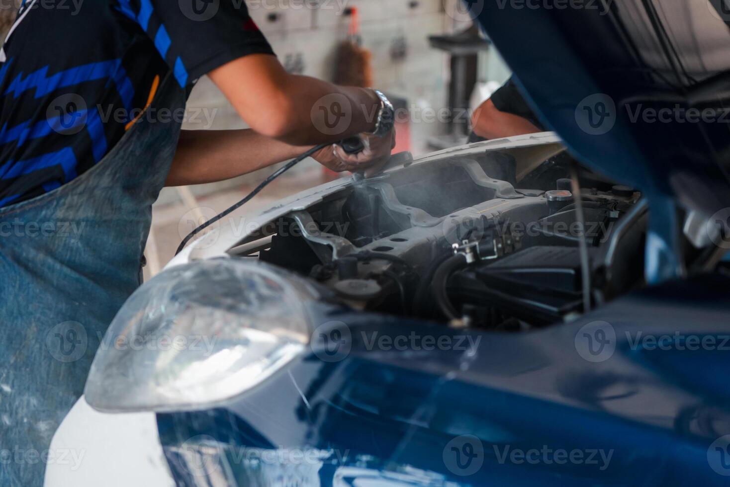 A man is working on a car engine photo