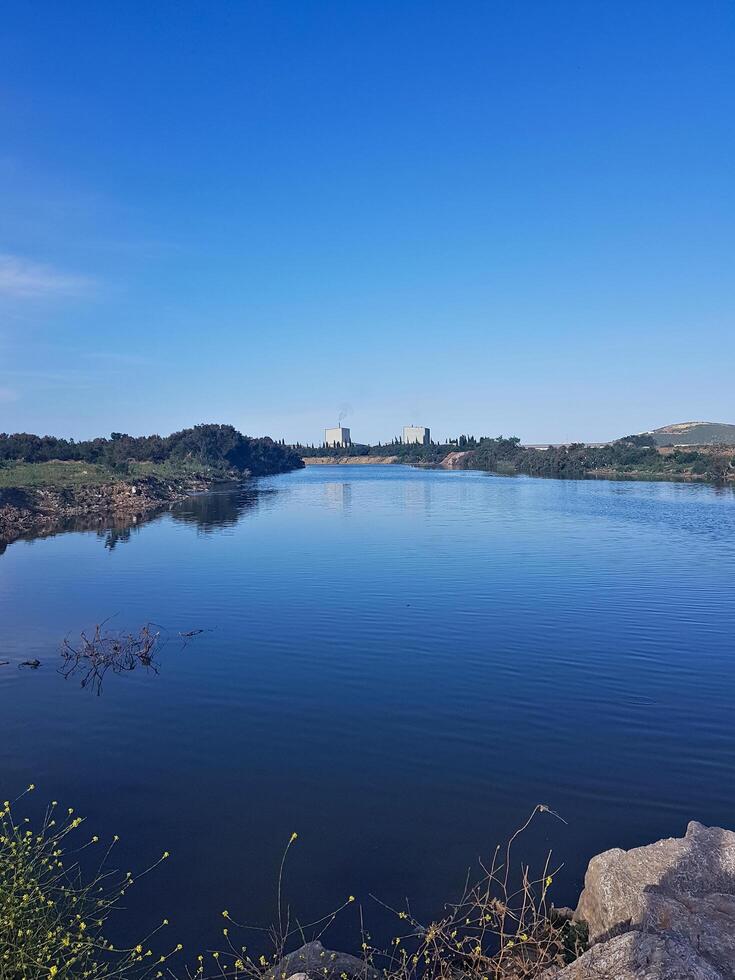 a peaceful lake rests under the evening sky, beautifully framed by the surrounding landscape. its calm ambiance captures the true essence of nature's embrace. photo