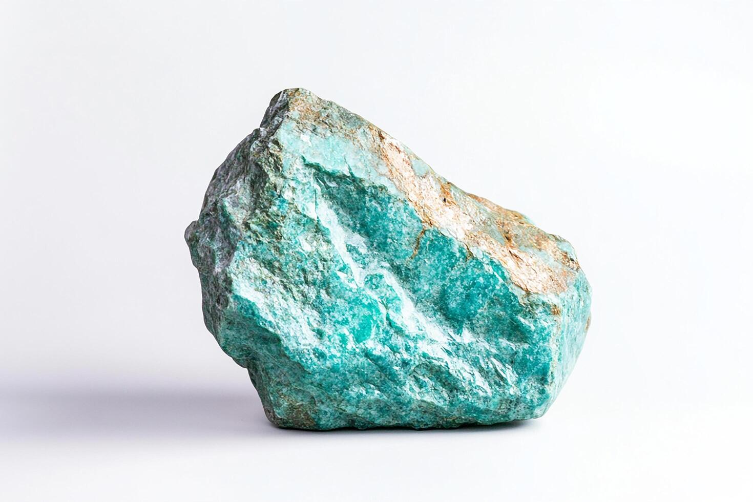 Close up shot of a turquoise colored rock formation against a plain white background space photo