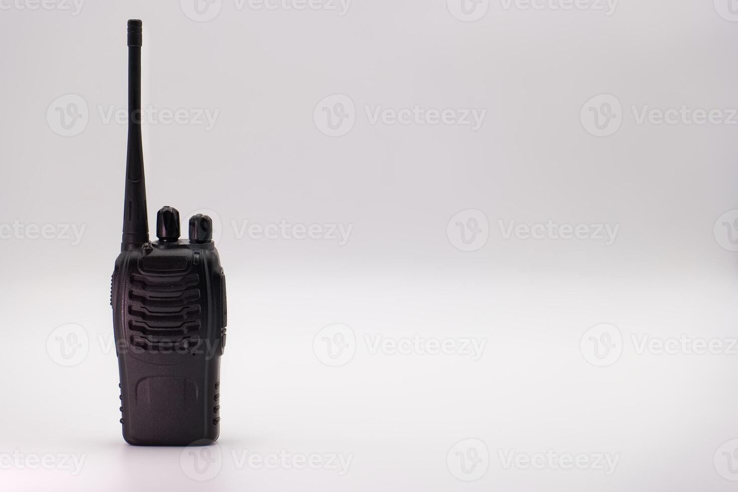 Walkie talkie resting on a surface with simple background highlighting its features and design photo