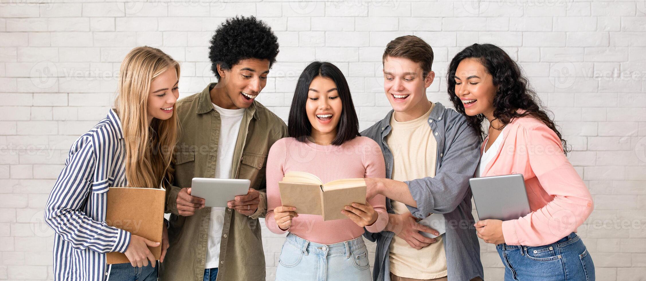 Youth lifestyle and friendship, teamwork and study in college or university. Surprised asian young lady found information, friends hold gadgets and look at book in classroom, studio shot, empty space photo