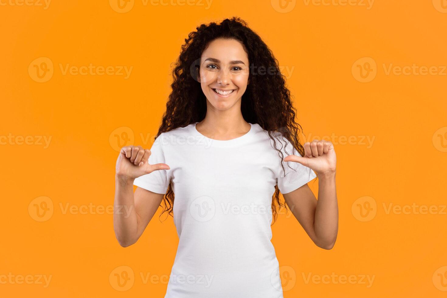 Look At Me. Happy Lady Pointing Fingers Thumbs At Herself Posing Standing On Yellow Background, Smiling To Camera. Studio Shot. Choose Me. Self-Confidence Concept. Panorama photo
