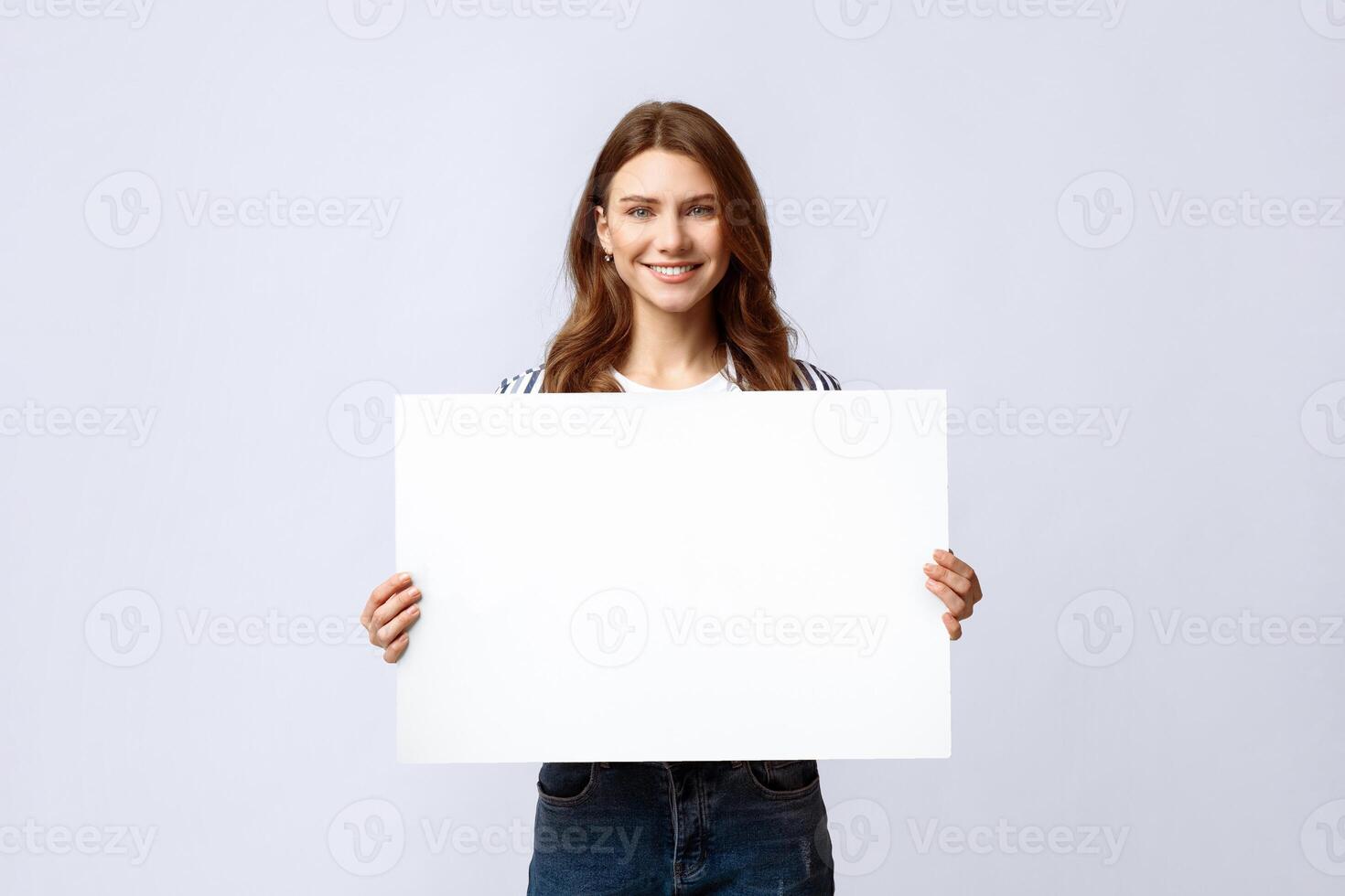 Smiling Millennial Lady Holding Blank Placard With Copy Space For Advertisement. Positive Young Woman Showing Empty Poster With Free Place For Your Text Or Design, Standing On Light Studio Background photo