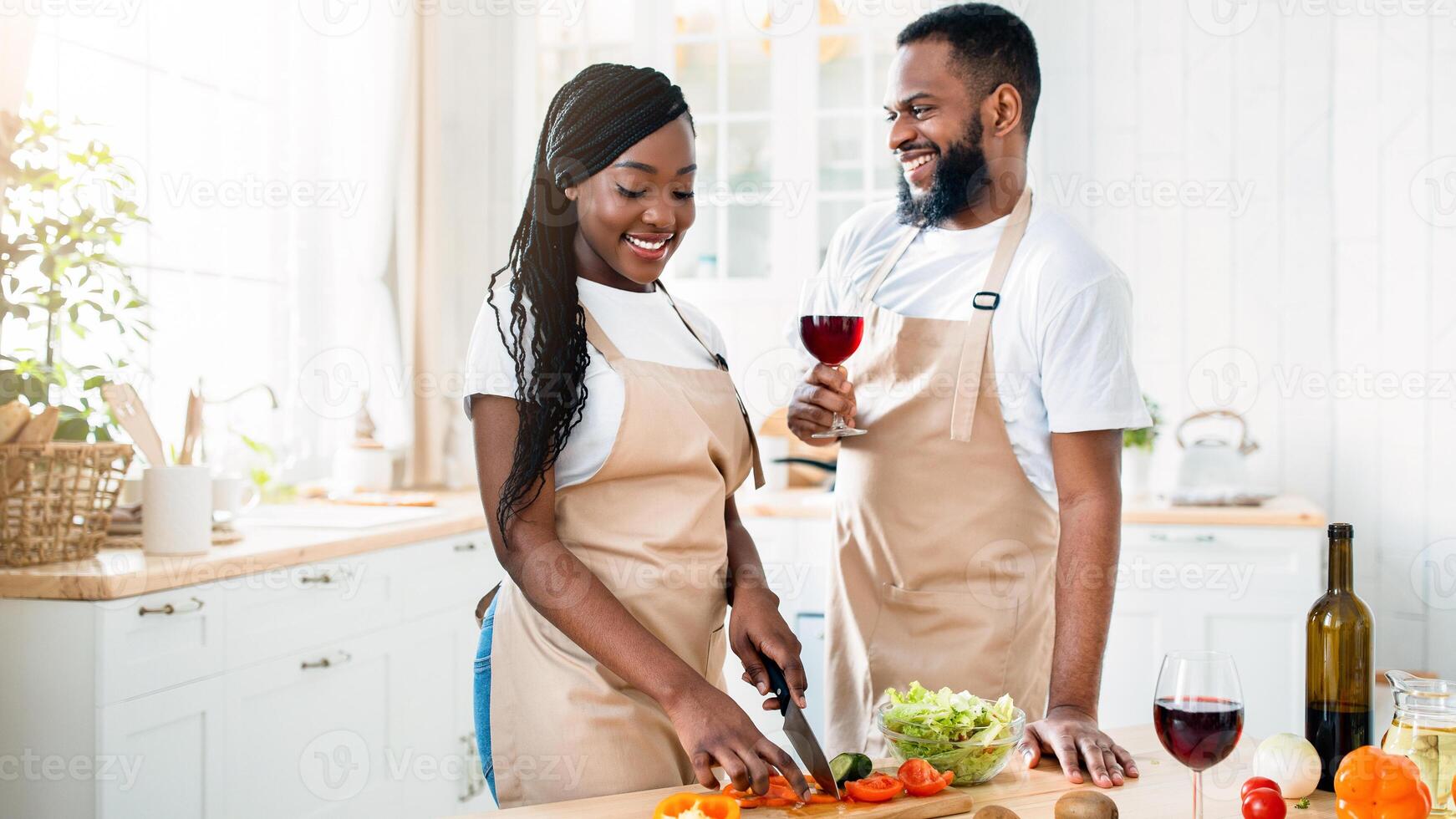 Aperitif Drink. Happy Black Spouses Drinking Red Wine While Cooking Food In Kitchen, Loving Young African American Couple Preparing Healthy Lunch Together And Having Fun At Home, Free Space photo
