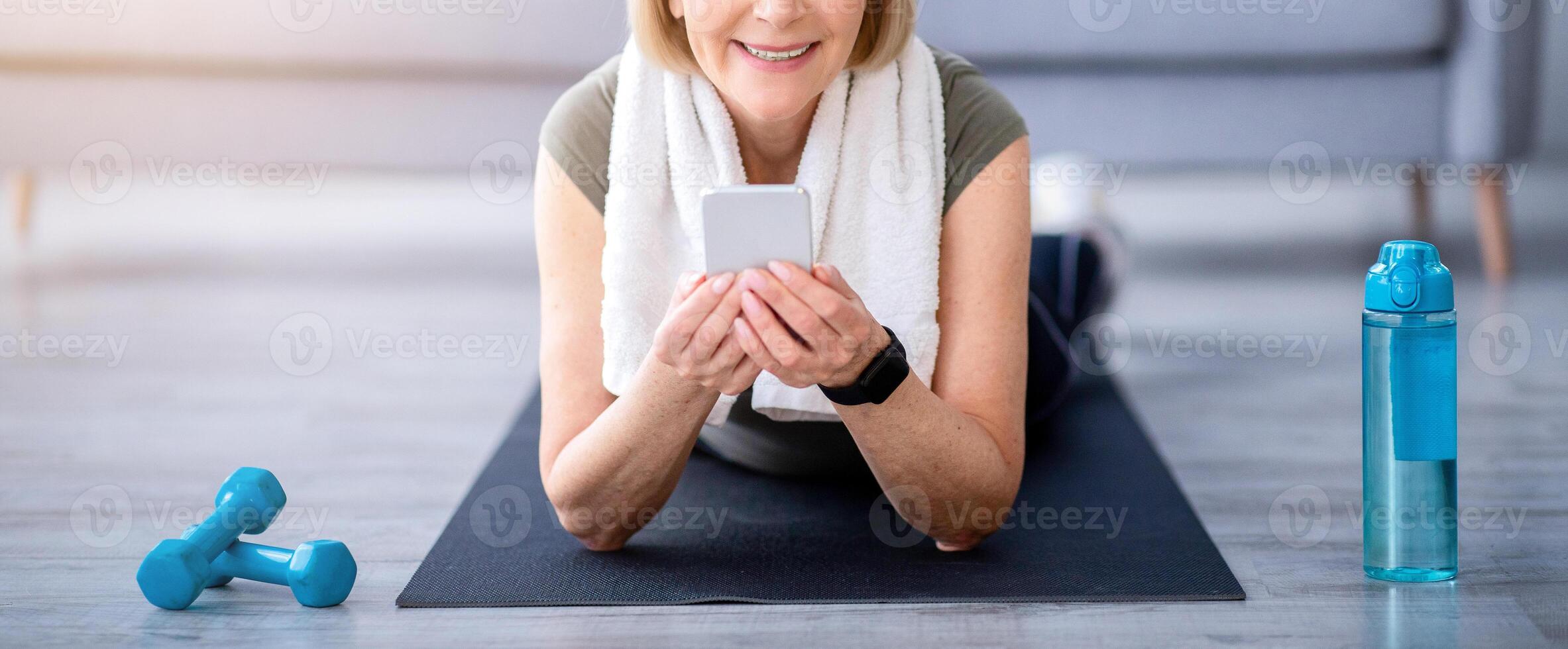 Senior woman doing exercise with smartphone photo