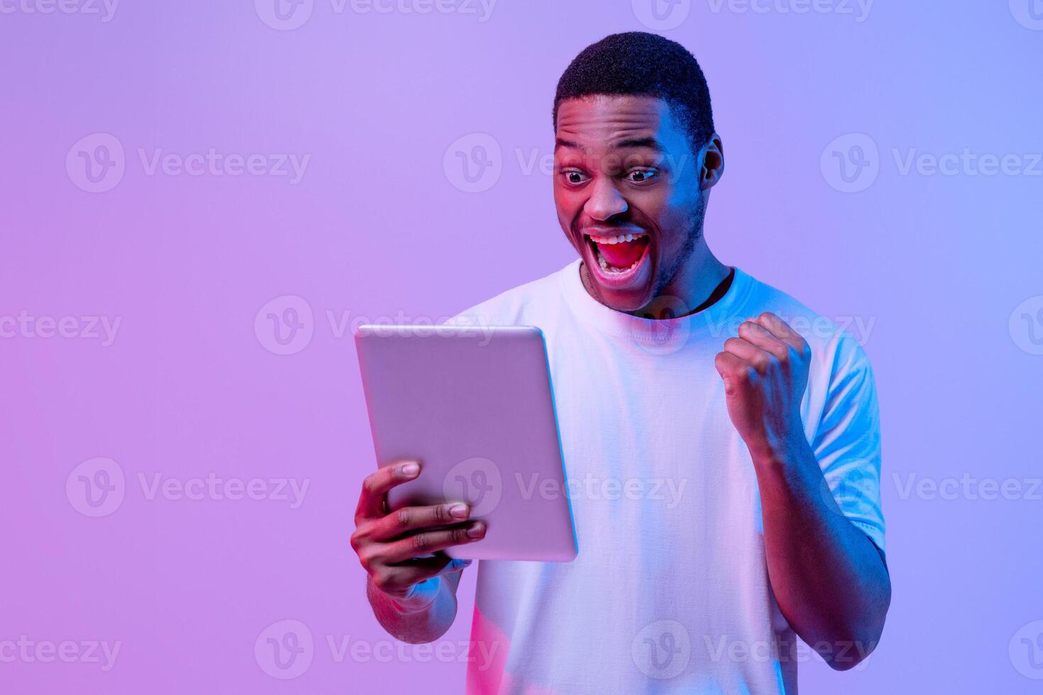 Man celebrating with a tablet photo