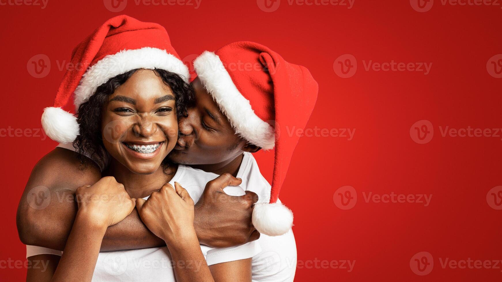 Couple in Christmas hats smiling together photo