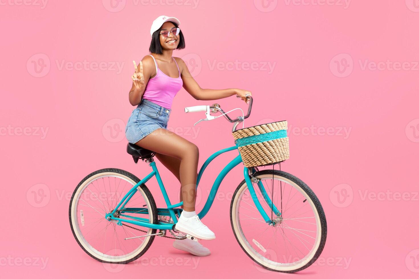 Woman on vintage bicycle with pink background photo