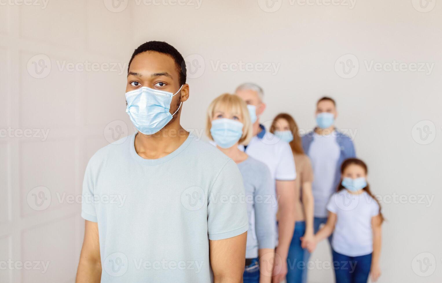 People in masks standing in line photo