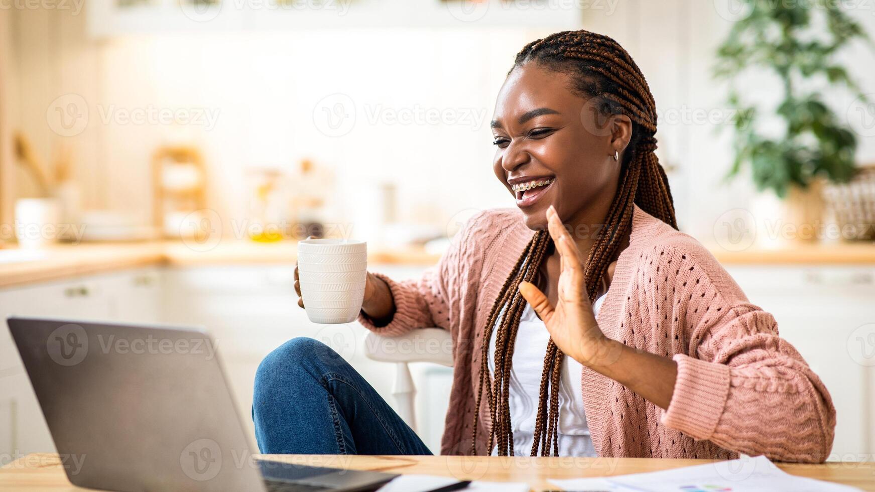 Woman smiling with coffee and laptop photo
