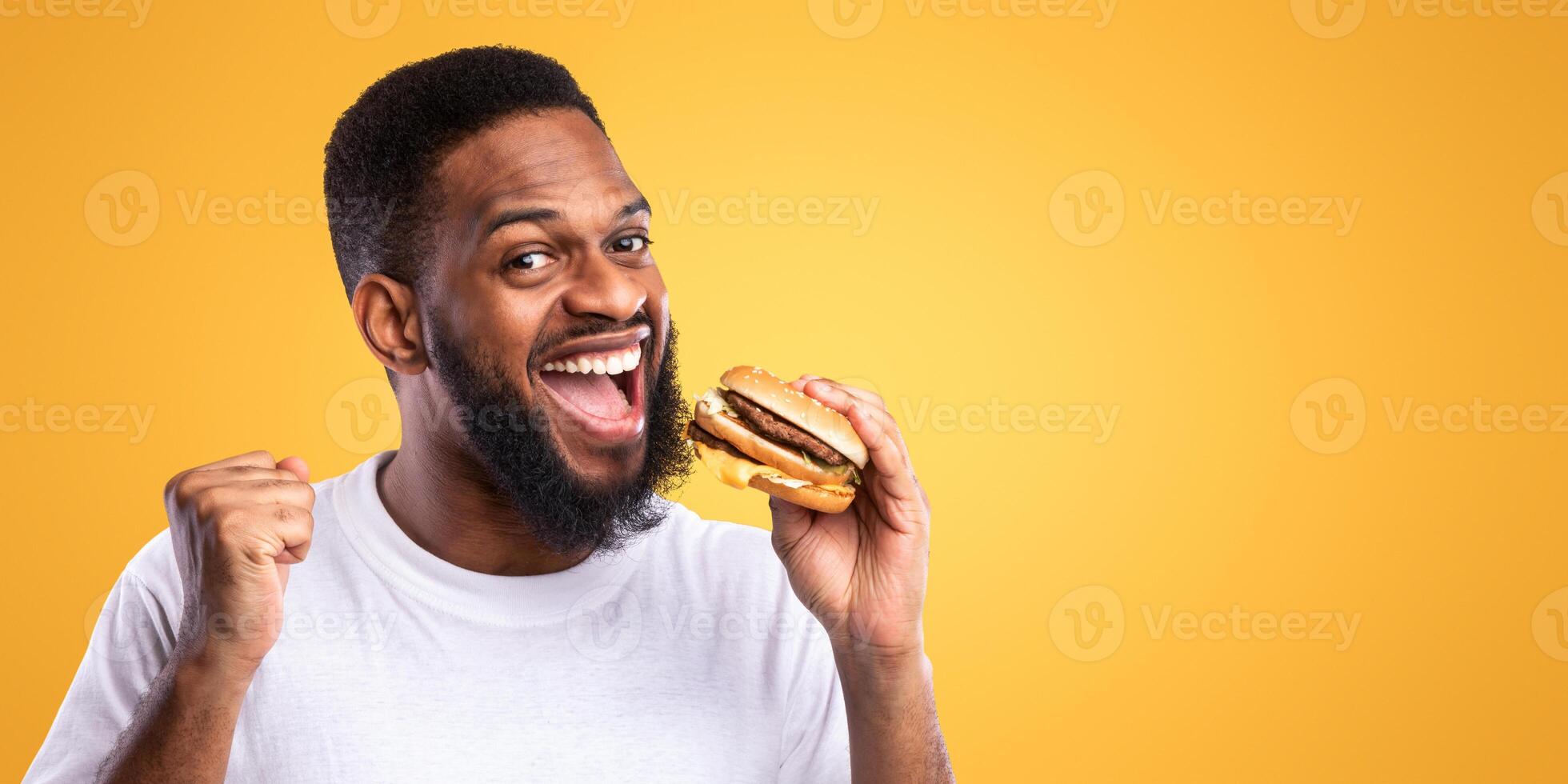 Man eating a hamburger with joy photo
