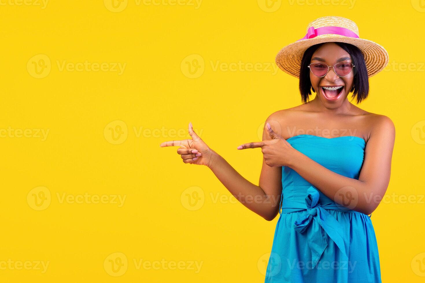 Lovely African American woman shouting WOW in excitement, pointing aside at free space on orange studio background, banner design. Pretty black lady offering unbelievable summer sale or discount photo