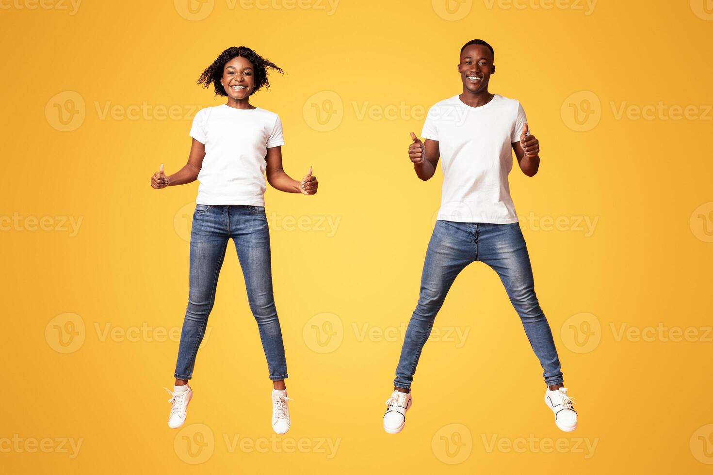 Young adults jumping with thumbs up photo