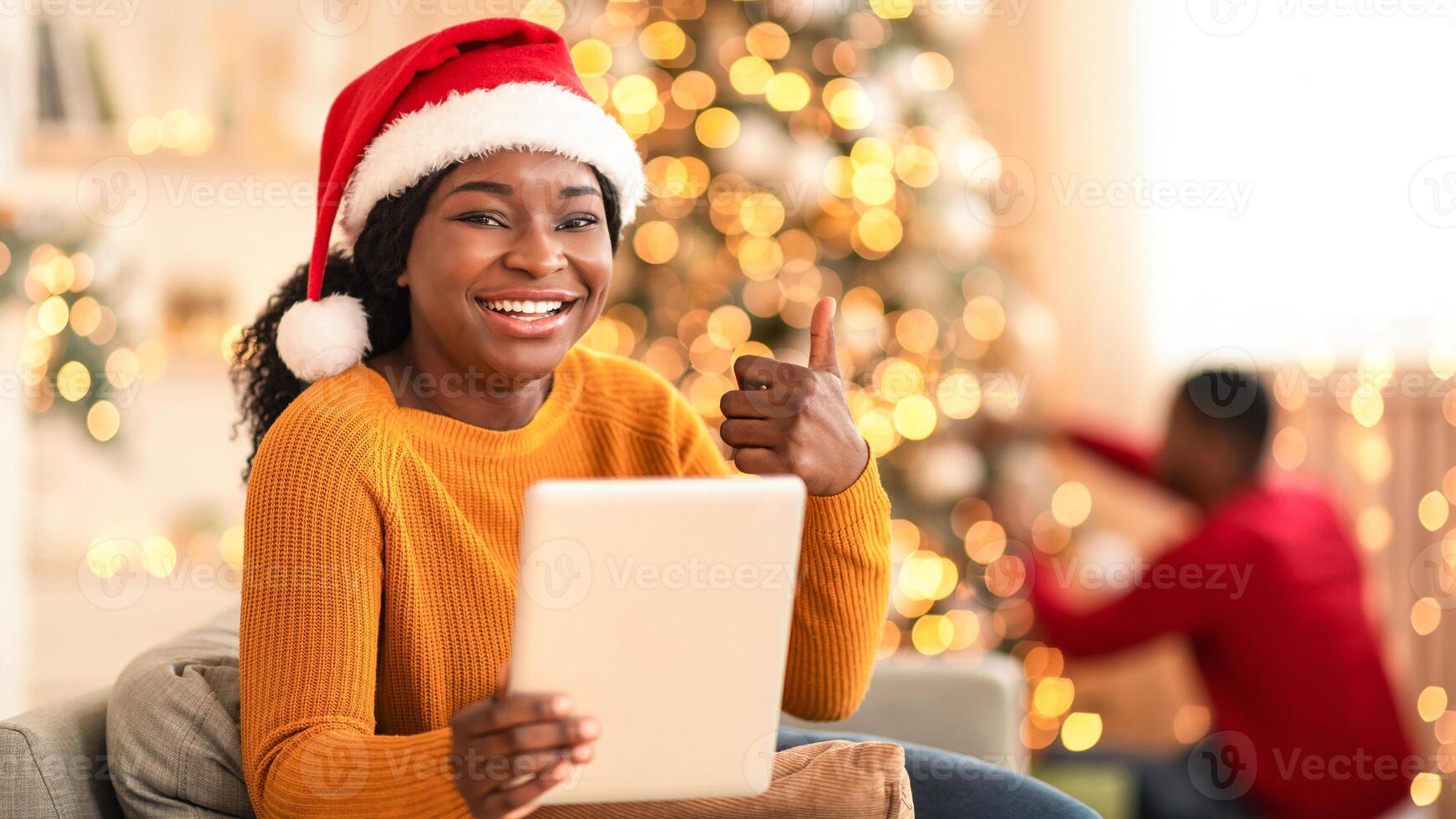 Happy woman with tablet and Christmas tree photo