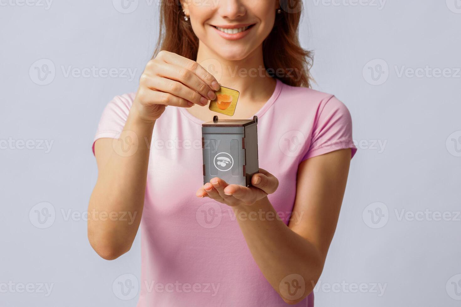 Food Waste Recycling. Conceptual Image With Young Woman Holding Small Grey Toy Recycle Bin Container, Unrecognizable Lady Standing Over Light Studio Background, Closeup With Free Space photo