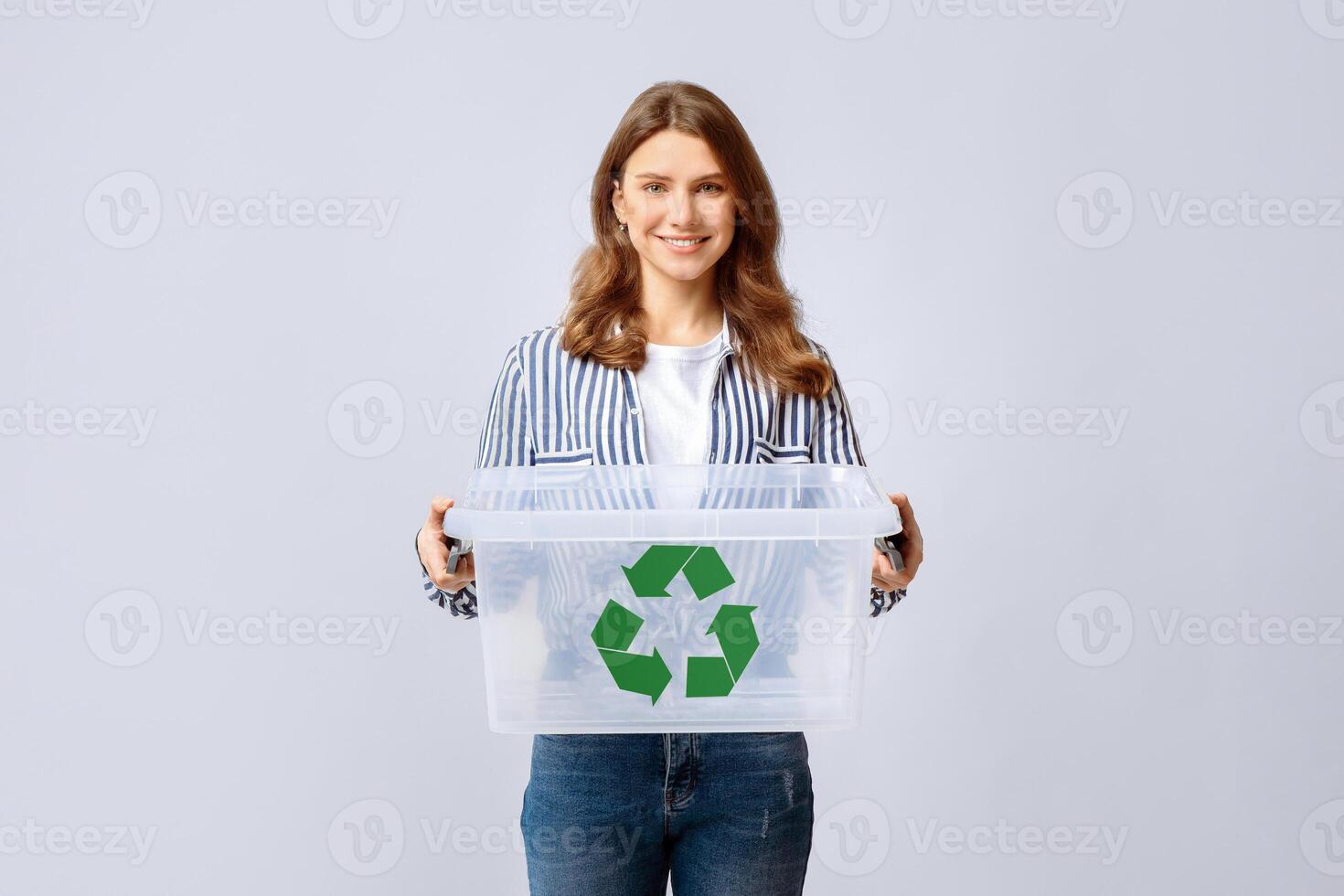 Smiling Young Woman Holding Empty Plastic Container With Green Recycle Sign Icon, Positive Millennial Woman Enjoying Zero Waste Living And Garbage Sorting, Standing Over Light Background, Copy Space photo
