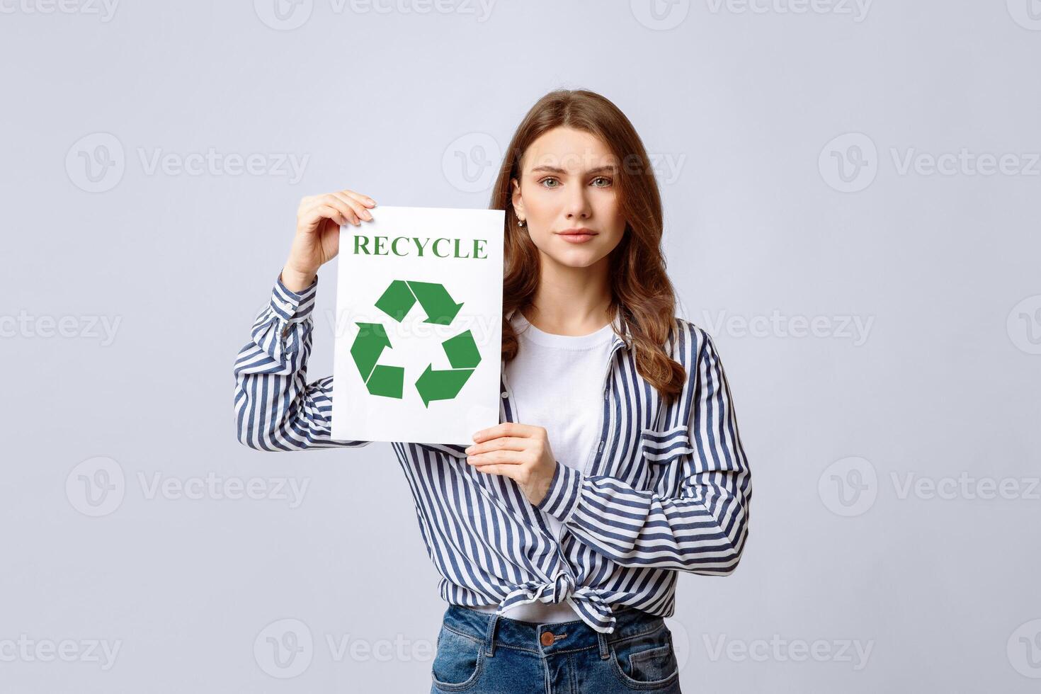 Young Environmental Activist Lady Holding Placard With Green Recycle Sign, Eco-Friendly Woman Enjoying Waste Sorting And Garbage Recycling, Posing On Light Studio Background, Copy Space photo