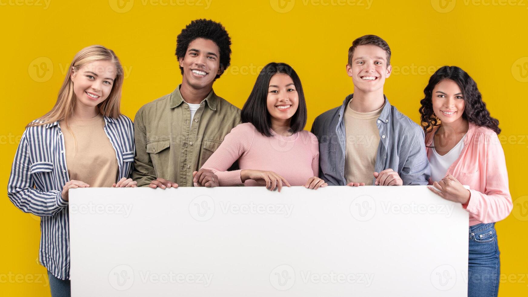 Education, ad and student recommendations. Diverse teens cheerful international students holding big banner with free space and ready to study at college, isolated on beige background, studio shot photo