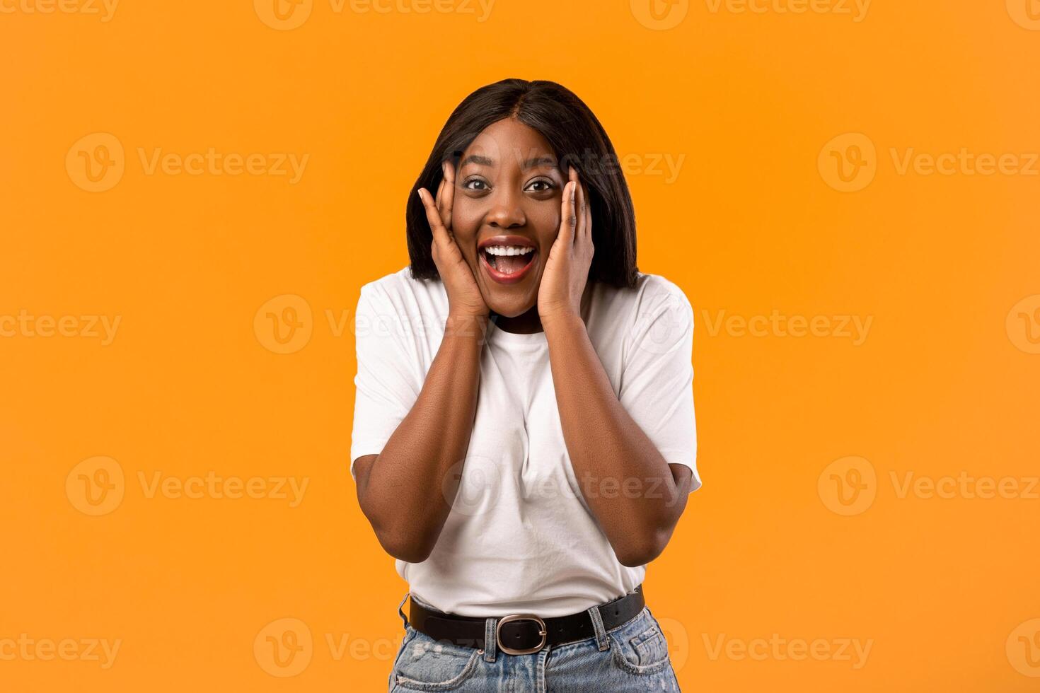 Excited woman smiling with hands on face photo