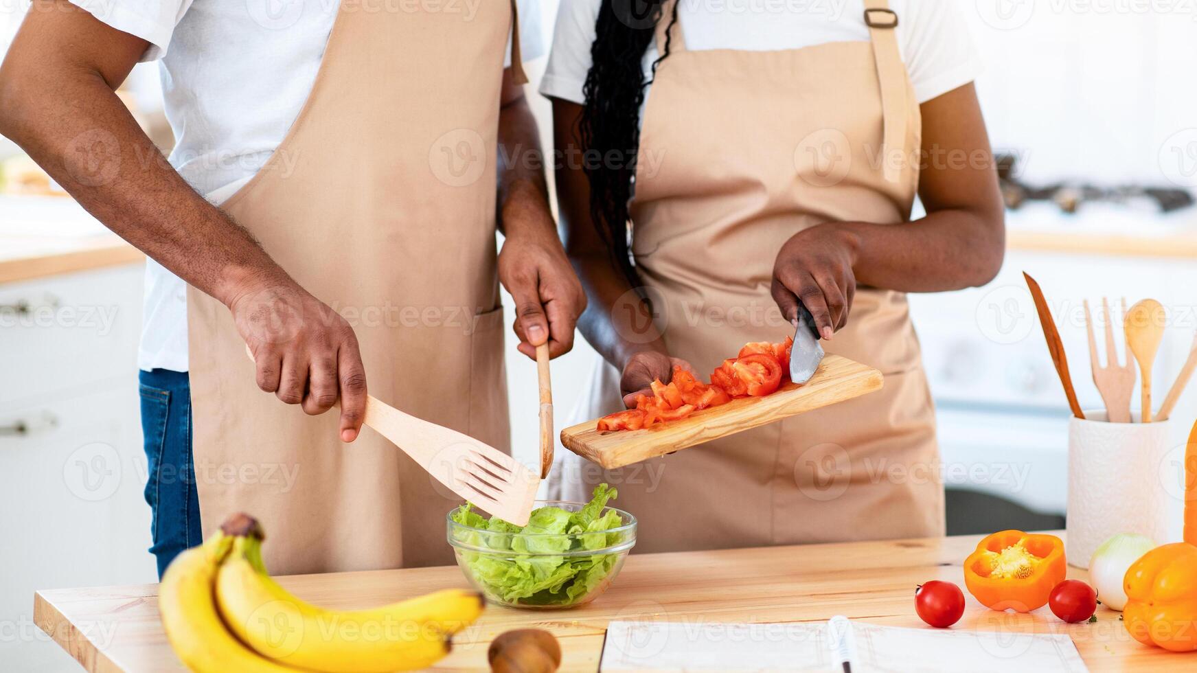 Couple cooking and preparing salad together photo