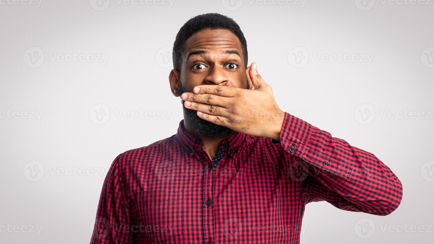 Surprised man covering mouth photo