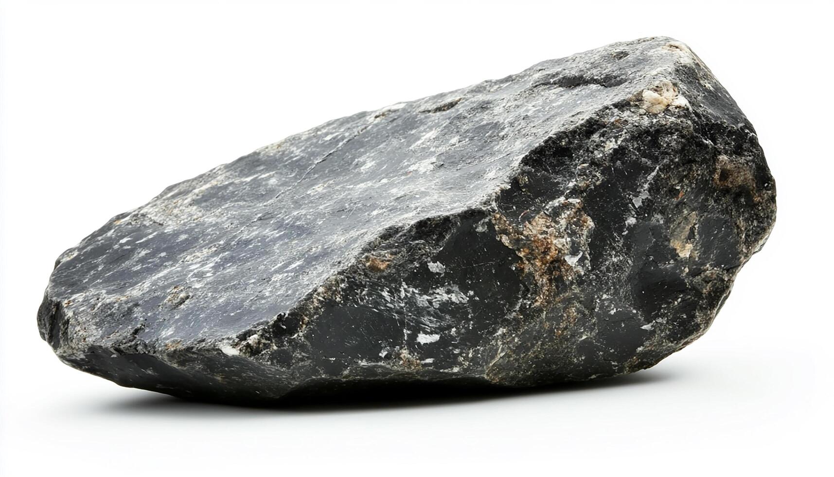 A single, large, dark gray rock with textured surface isolated on a white background space photo