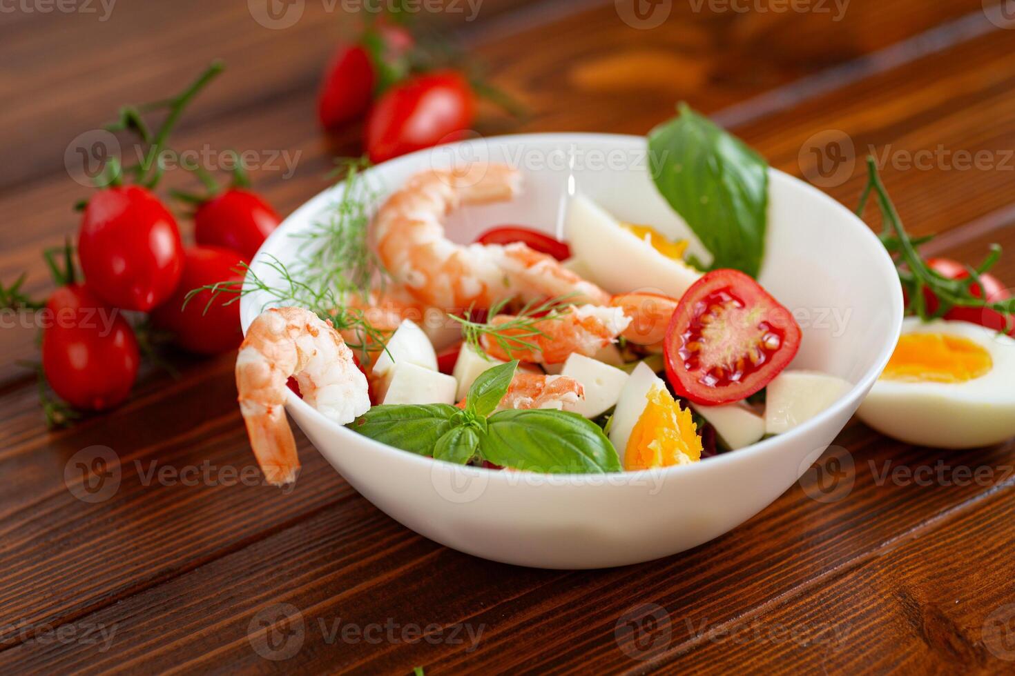 Delicious seafood salad with egg and basil close-up photo