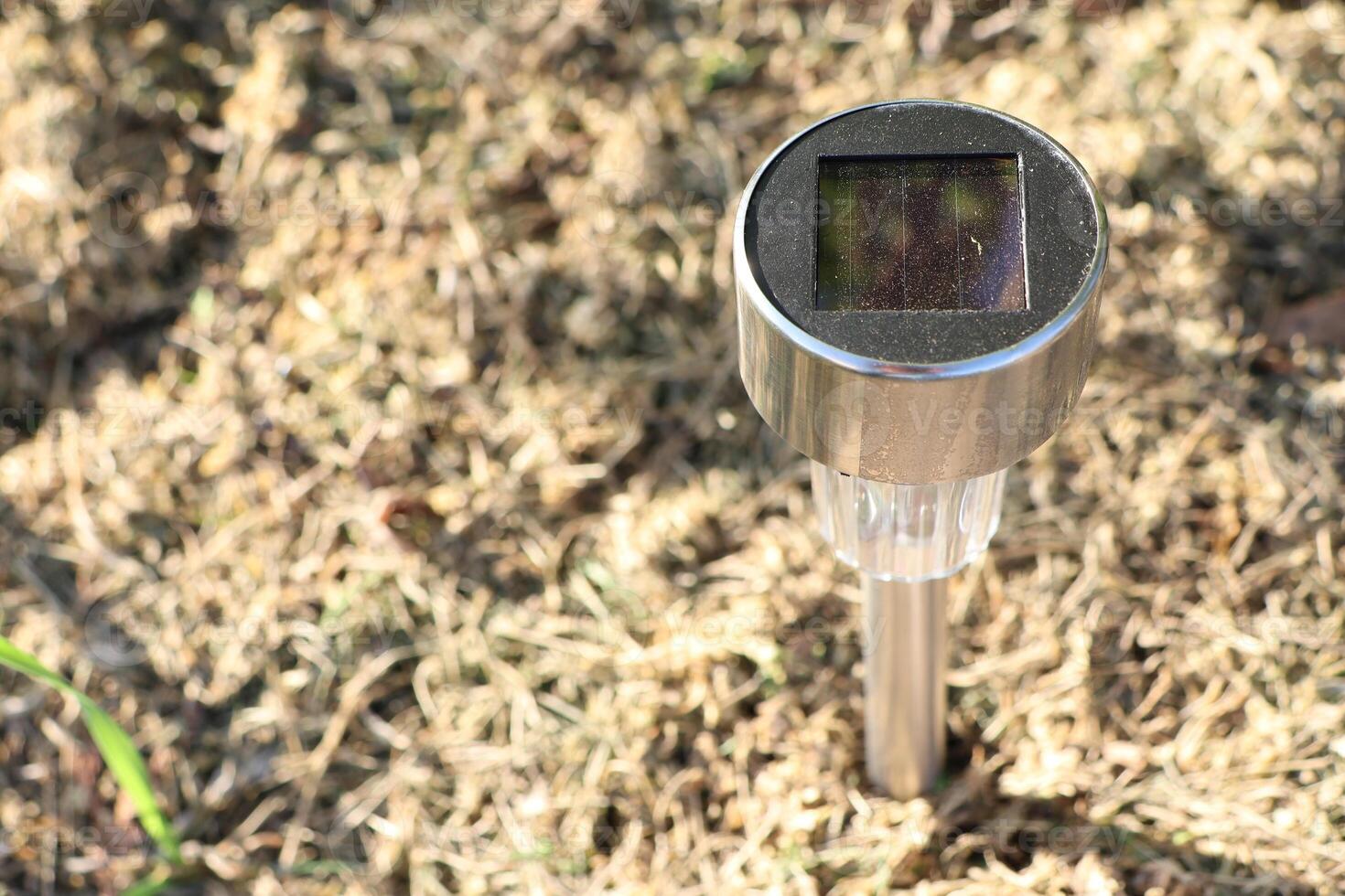 SolarPowered Garden Light Placed Securely on Grass for Outdoor Aesthetics and Illumination photo