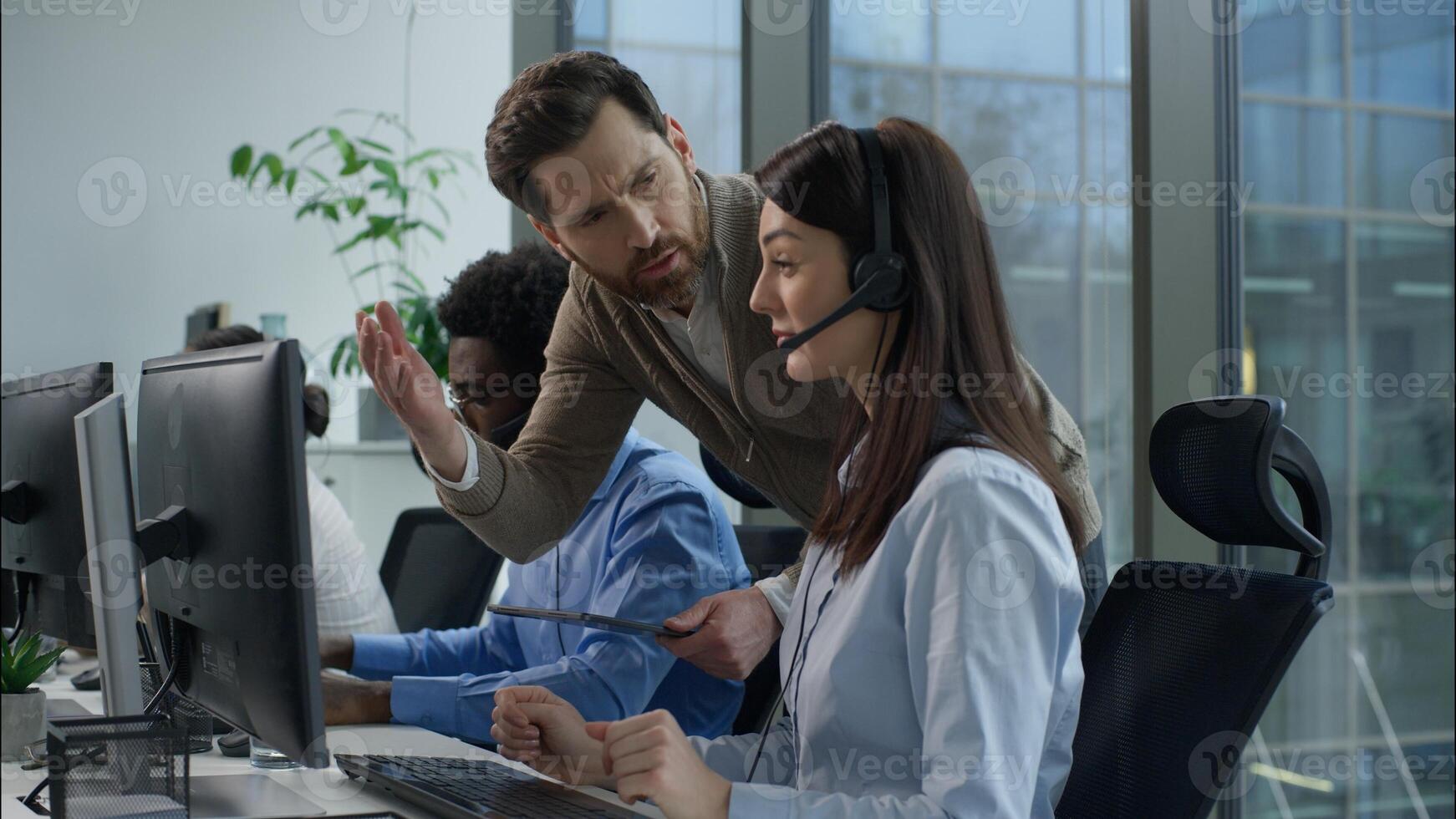 Multinational call center office conflict angry displeased Caucasian male supervisor scolds callcenter female operator African business man Indian woman working support headset tension stress problems photo