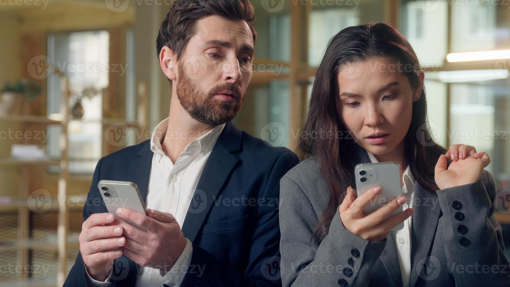 Multiethnic office business coworkers searching online smartphone internet Korean woman thoughtful scrolling mobile phone shaking finger no Caucasian man peeking screen solving issue digital research photo