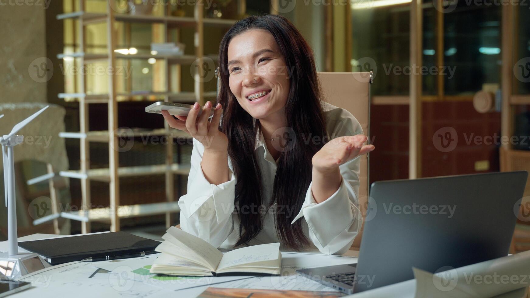 Asian businesswoman record audio message mobile phone send voice mail in office business woman friendly talking mic smartphone smiling Korean Japanese Chinese girl designer architect talk speakerphone photo