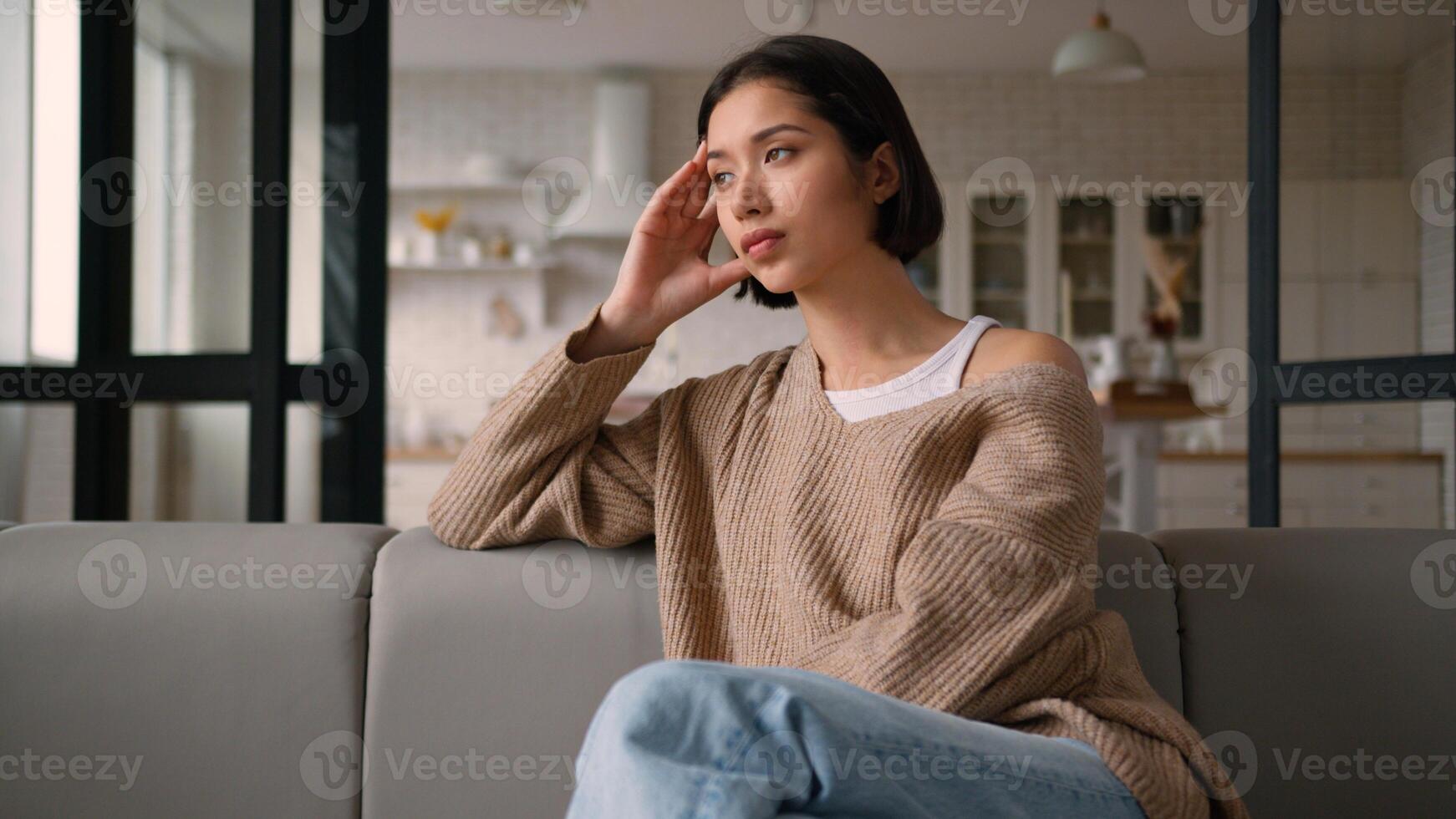 Sad Caucasian latin hispanic woman girl female tenant on sofa deep unhappy thoughts think looking away melancholic mood quarrel bored weekend alone home credit debt loan mortgage stress health problem photo