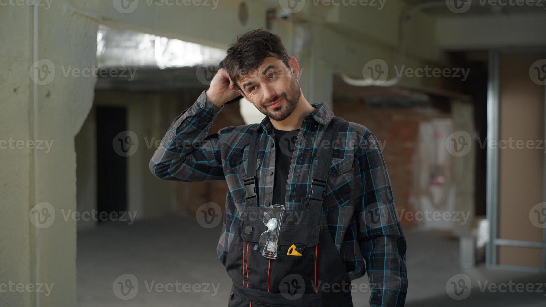 Man builder engineer on construction site working rubbing head thoughtful male Caucasian guy architect handyman foreman in uniform start work building technician electrician repairman industrial job photo