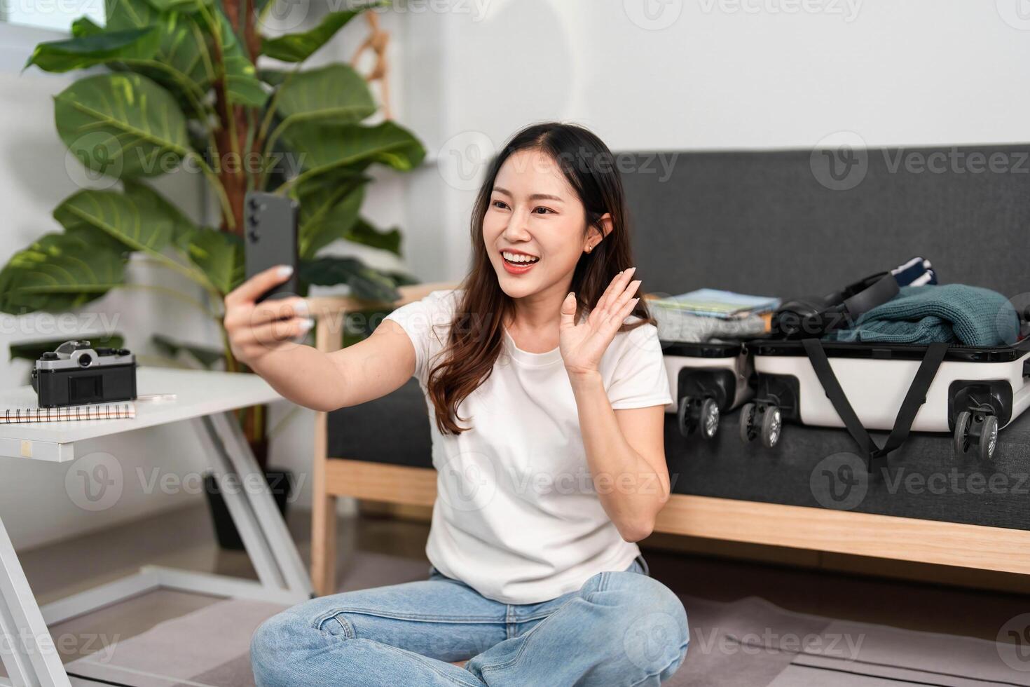 Joyful Travel Preparation. Young woman smiling while taking a selfie during her packing process. photo
