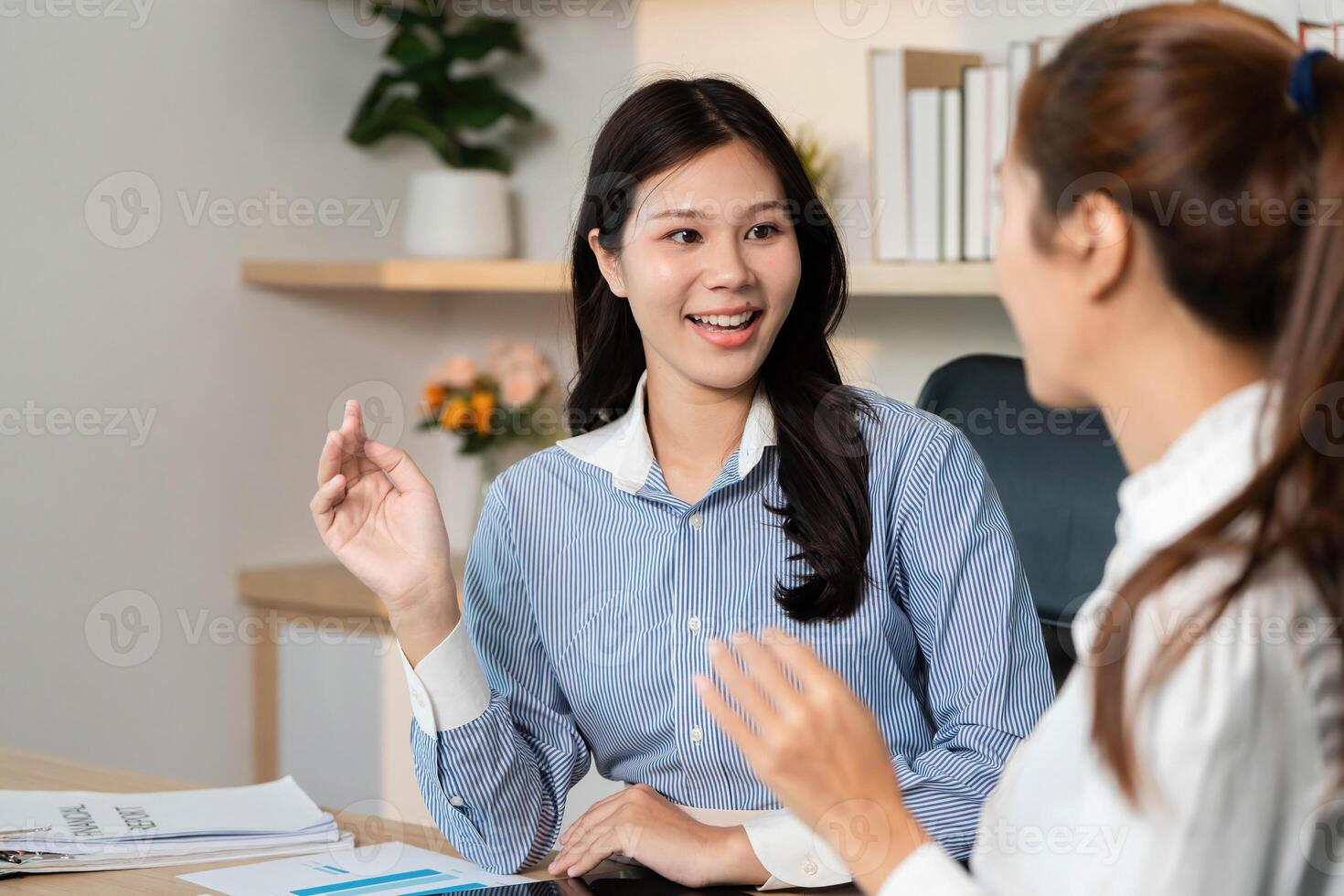 Business Strategy Discussion. Female professionals sharing ideas and data analysis in office setting. photo