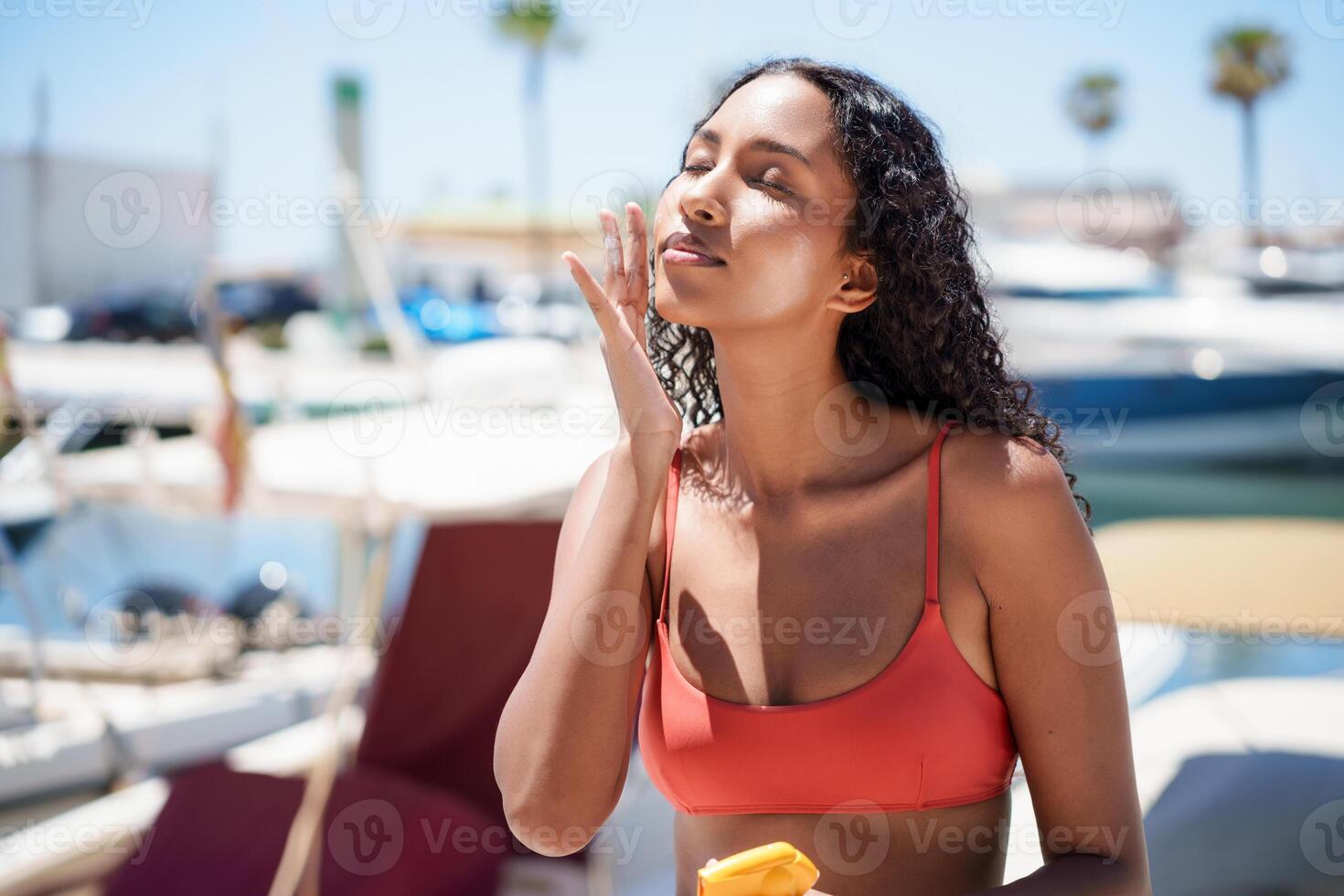 Spending a beautiful and enjoyable sunny day by the water applies sunscreen photo