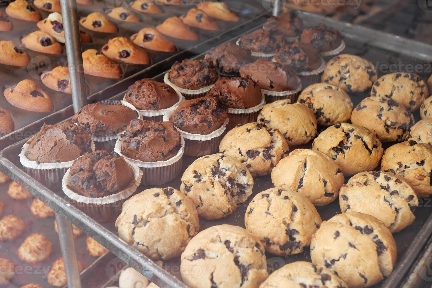 Muffins and cupcakes displayed in a bakery case photo