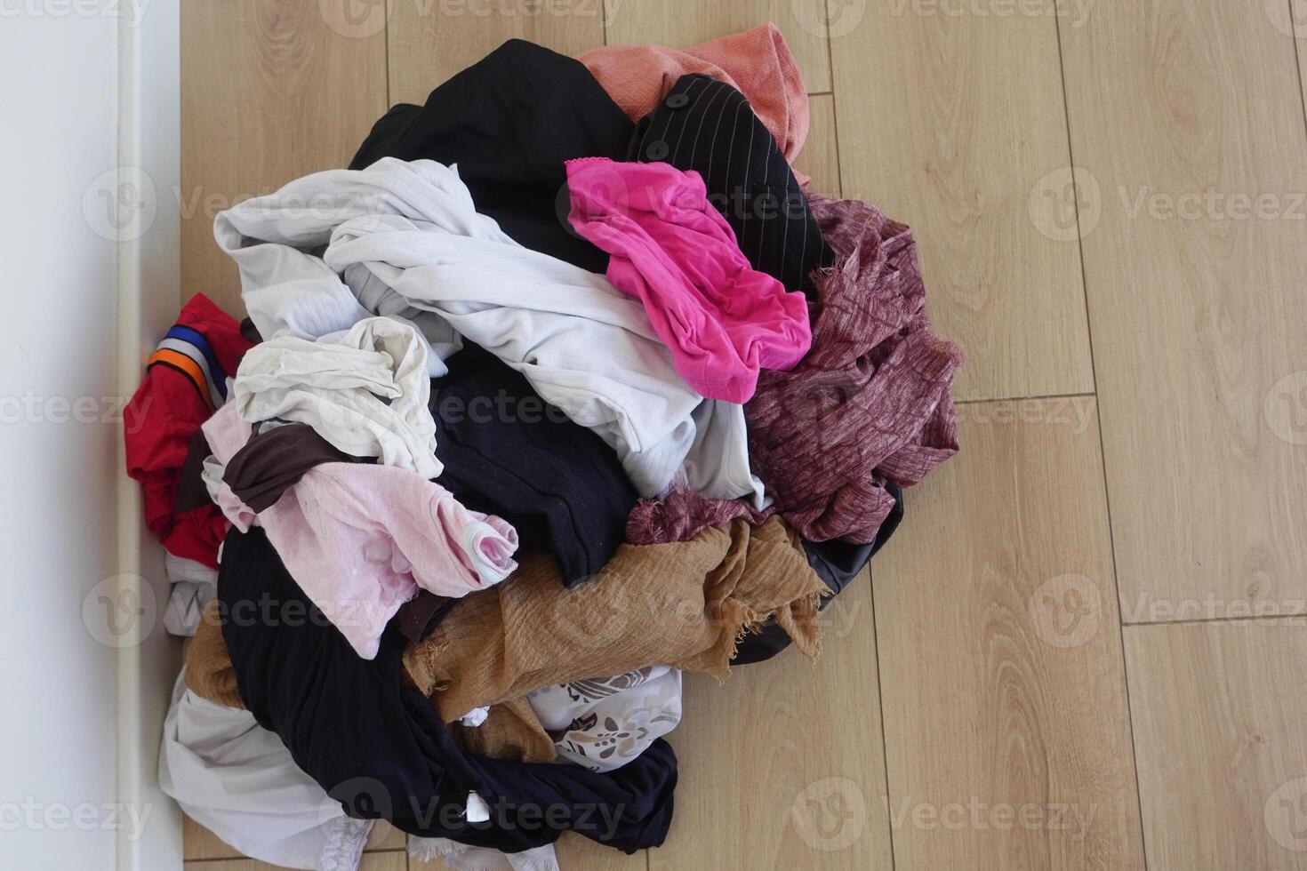 Laundry pile mixed with clean and dirty clothes on floor photo