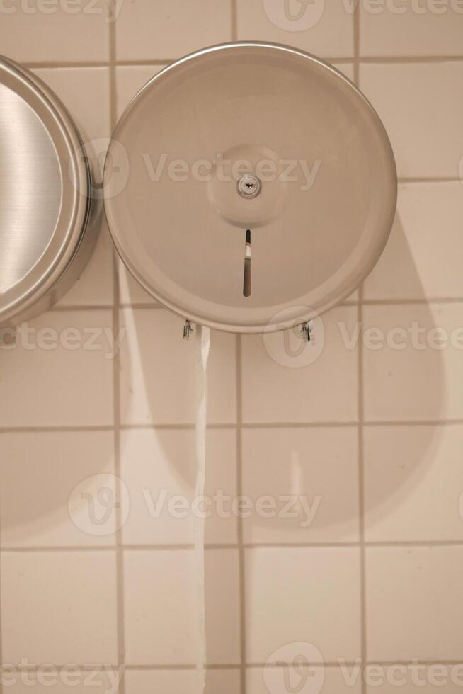 Hand sanitizer dispenser mounted on a tiled wall photo