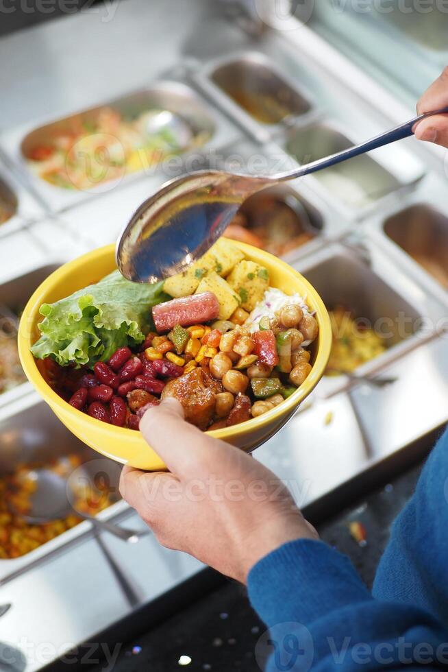 Creating a colorful bowl of mixed ingredients at a salad bar photo