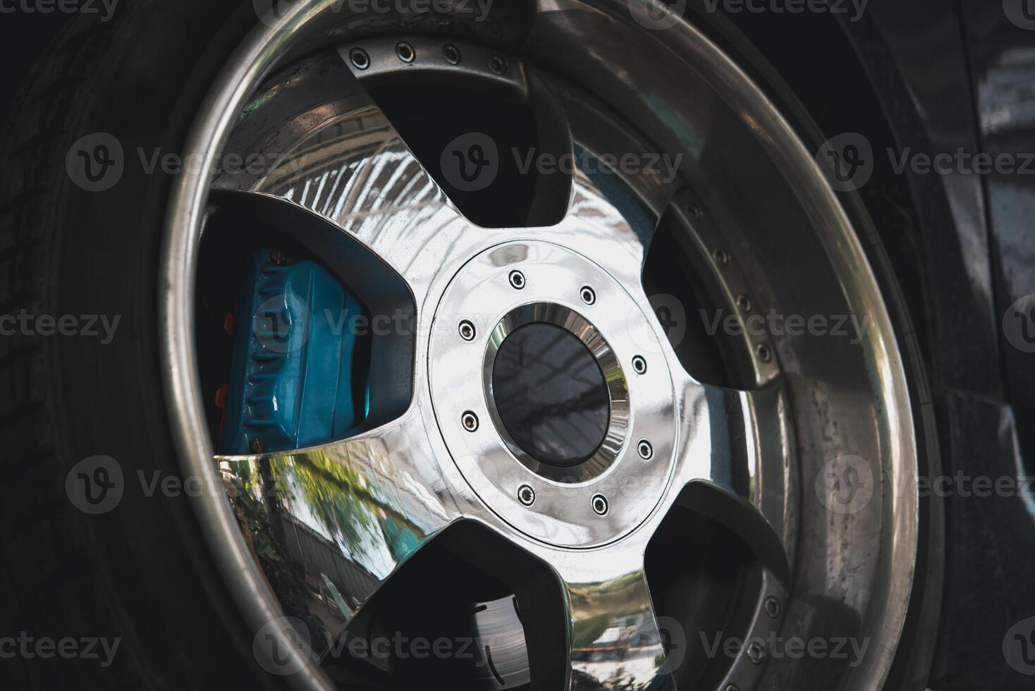 A close up of a car wheel with a blue and white sticker photo