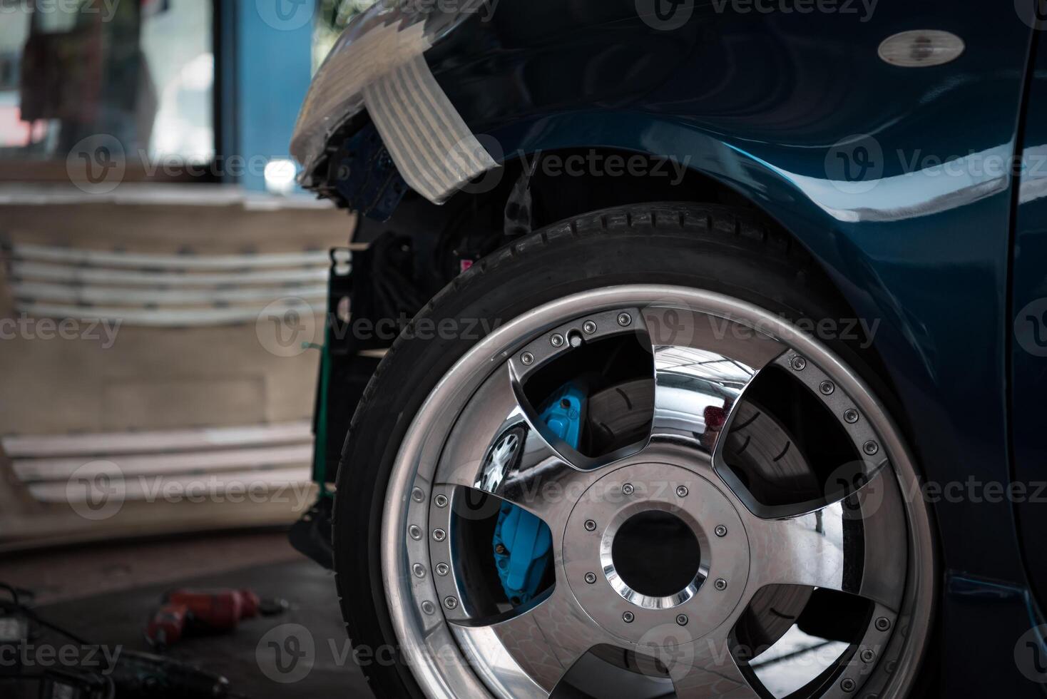 A blue car with a wheel and tire photo