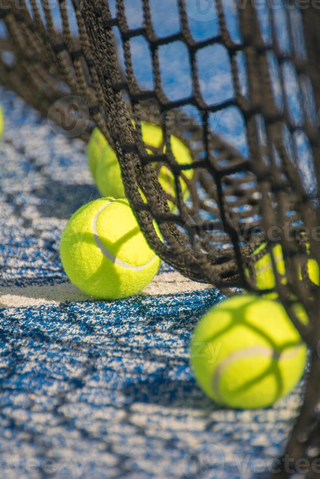 Padel Court Perspective Net and Yellow Tennis Balls in Sunlight photo