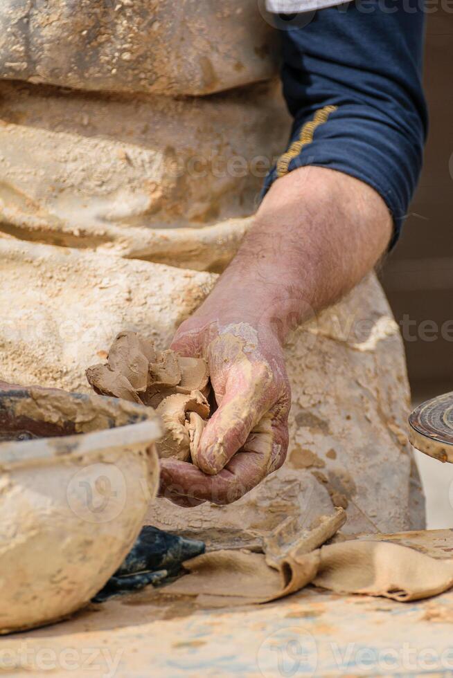 detail of traditional pottery making process, artist preparing material pottery on a wheel photo