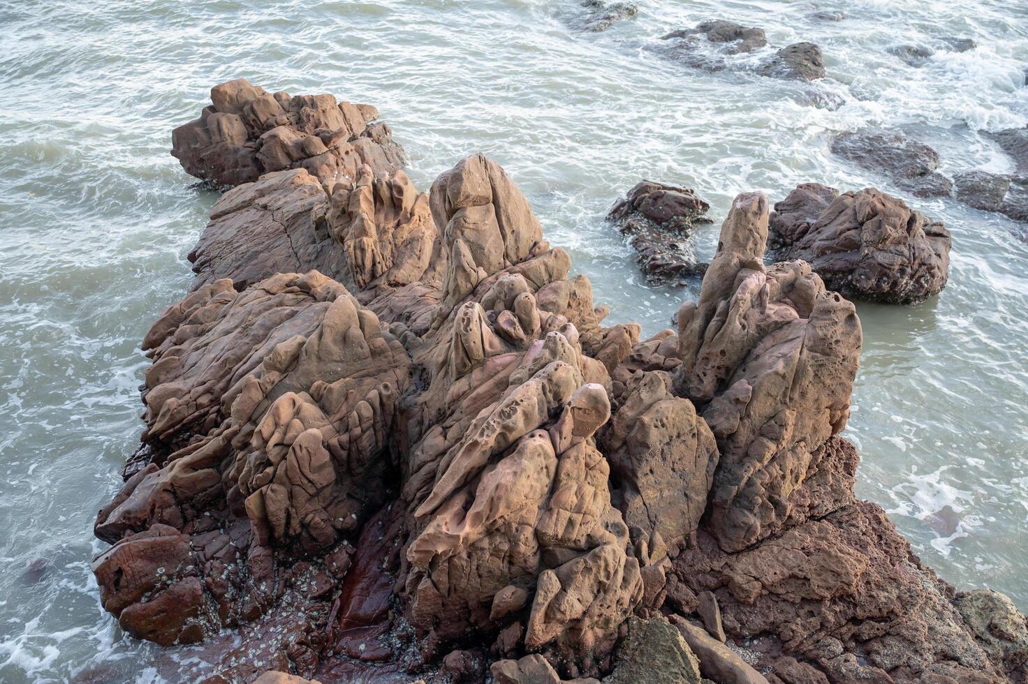 a rocky shore with waves crashing against it photo